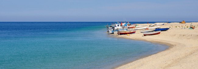Spiaggia con barche colorate sulla sabbia vicino al mare.