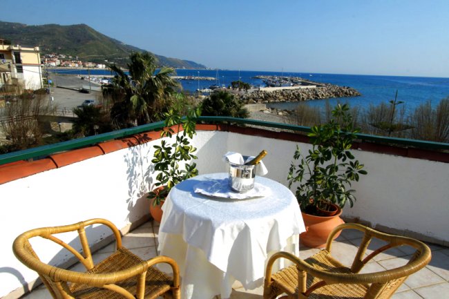 Tavolo con sedie in terrazza vista mare.