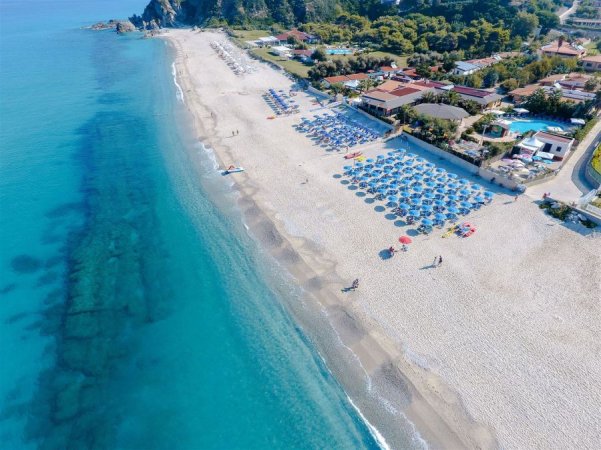 Spiaggia con ombrelloni e mare cristallino.