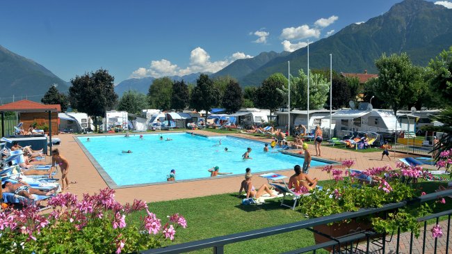 Piscina all'aperto con persone che nuotano.