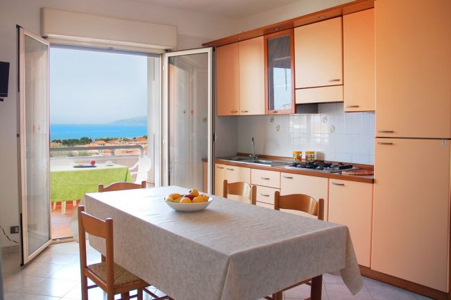 Cucina con vista sul mare e tavolo apparecchiato.