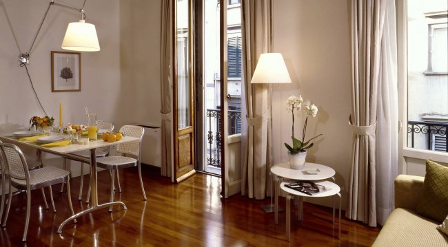 Soggiorno moderno con parquet, tavolo e divano.