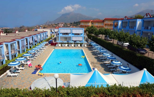 Piscina con lettini e ombrelloni blu.