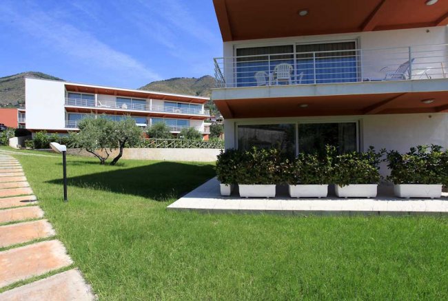 Edifici moderni con terrazze, prato curato.