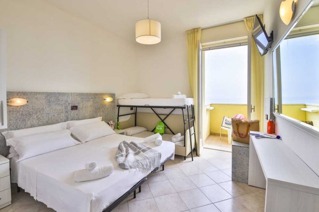 Camera con letto matrimoniale e letti a castello, balcone.