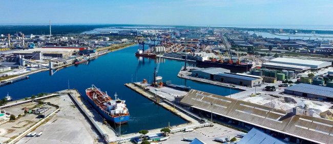 Porto con navi e strutture industriali.