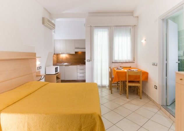 Camera con letto, tavolo e cucina.