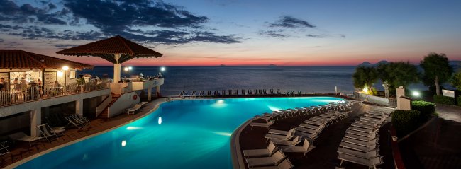 Piscina al tramonto con vista mare.