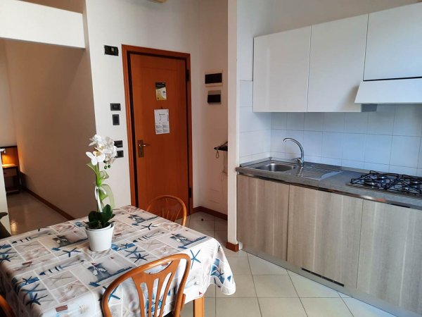 Cucina compatta e tavolo con fiori.