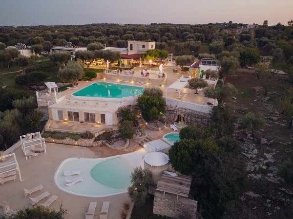 Complesso turistico con piscine e vegetazione.