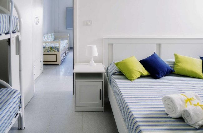 Camera con letti a castello e matrimoniali.