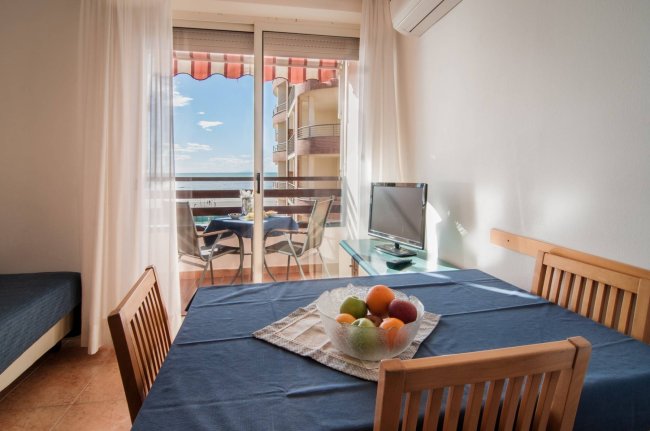 Tavolo con frutta e vista su terrazza con tavolo esterno.