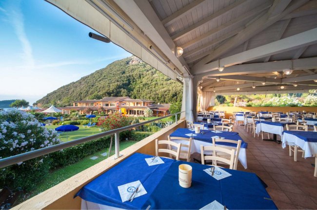 Terrazza ristorante con vista su colline e mare.