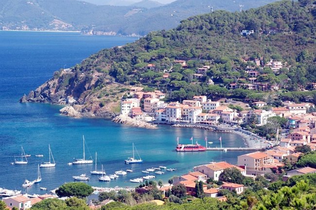 Panorama di una baia con barche e case lungo la costa.