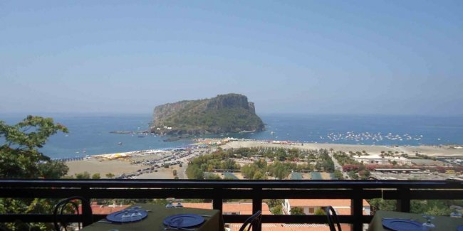 Tavoli con vista sul promontorio in lontananza.