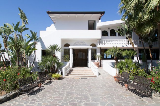 Ingresso di un edificio bianco con giardino.