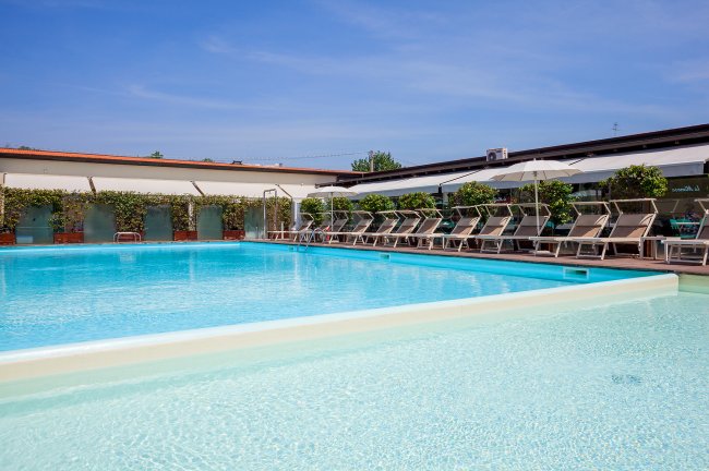 Una piscina scoperta con sedia a sdraio su un lato.