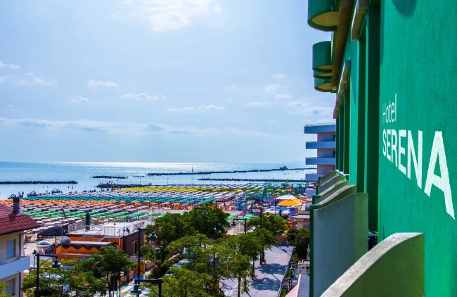 Balconi di hotel affacciati sulla spiaggia con ombrelloni colorati.