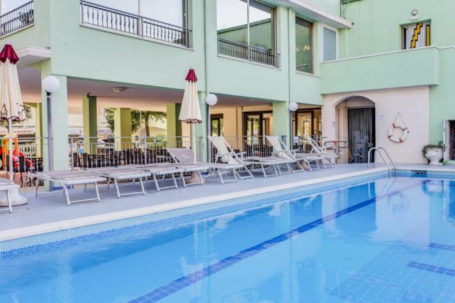 Piscina con lettini e ombrelloni.