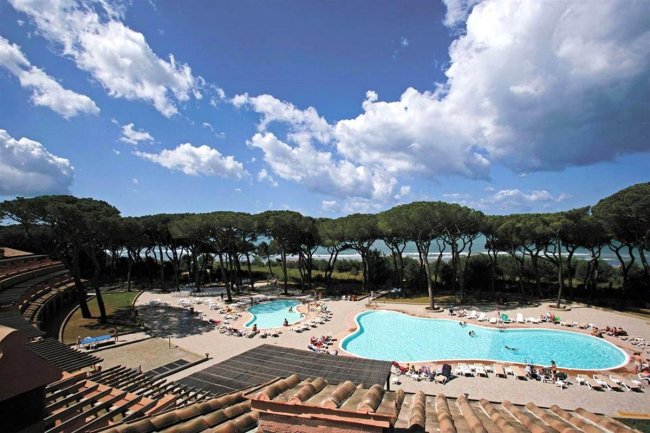 Vista di due piscine circondate da pini.