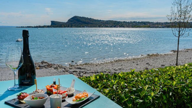 Tavolo con stuzzichini e vino vista lago.