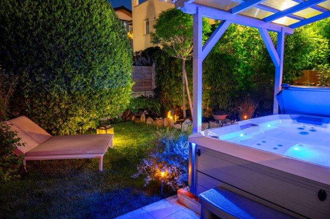 Giardino con jacuzzi e lettino.