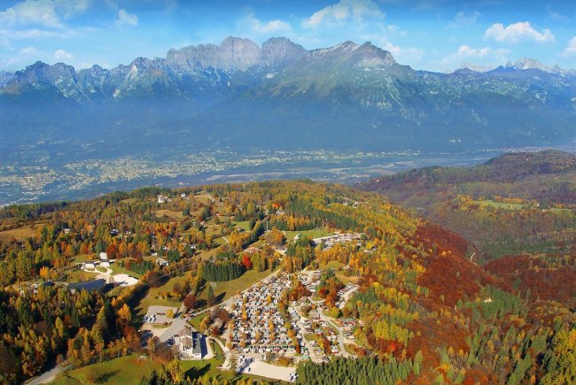 Paesaggio montano autunnale con villaggio e foresta.