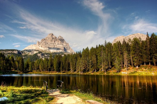 Lago con montagne e alberi sullo sfondo.