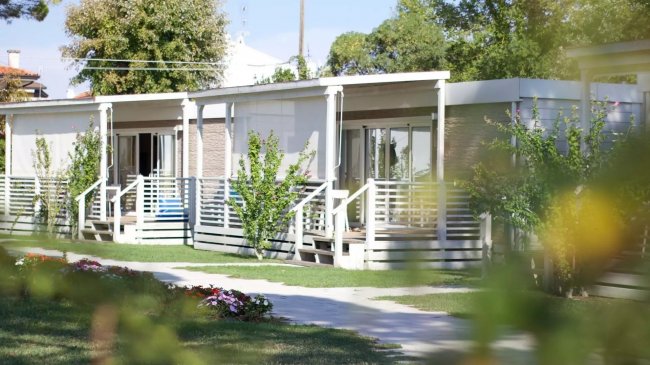 Un complesso di bungalow con terrazze e giardino curato.