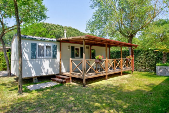 Casa mobile con veranda in legno e giardino.