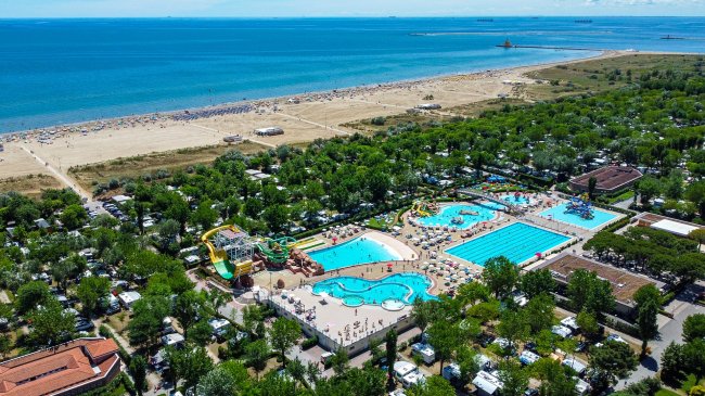 Complesso con piscine e spiaggia vicino al mare.