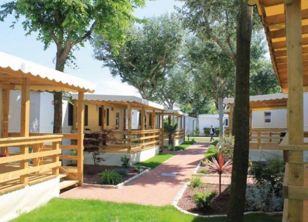 Bungalow con verande in un'area alberata.