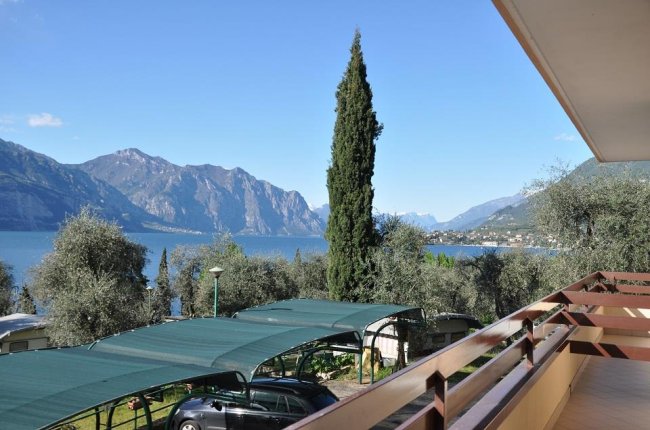 Vista su lago e montagne da un balcone.