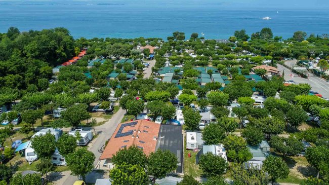 Un campeggio alberato vicino al mare.