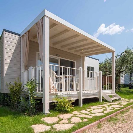 Veranda di una casa mobile con mobili bianchi.