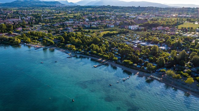 Vista aerea di un paesaggio costiero con litorale alberato.